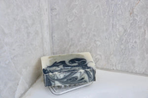 Clear, plastic, flexible mini soap lift holding soap in shower.  